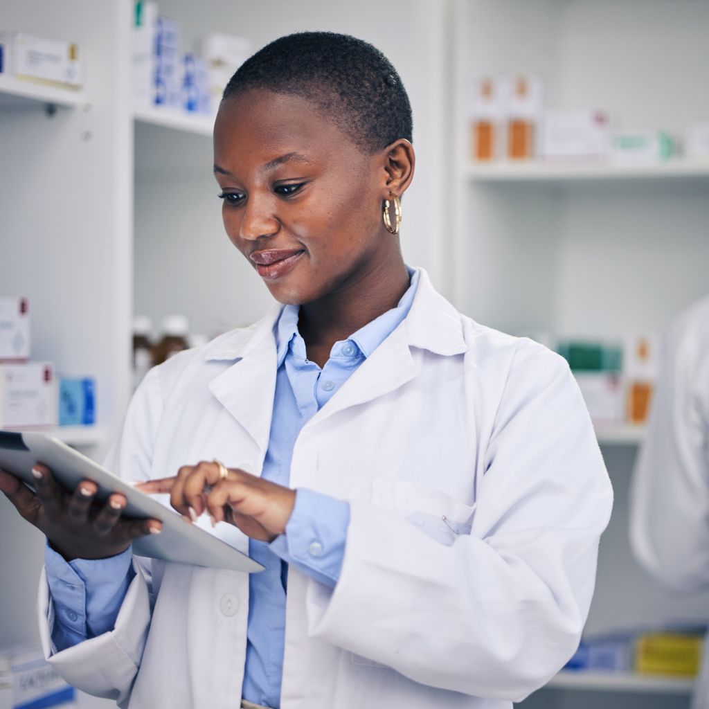 A pharmacist checking information on the tablet in a medication storage room
