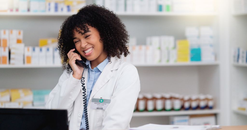 A pharmacist answering the phone at the pharmacy counter